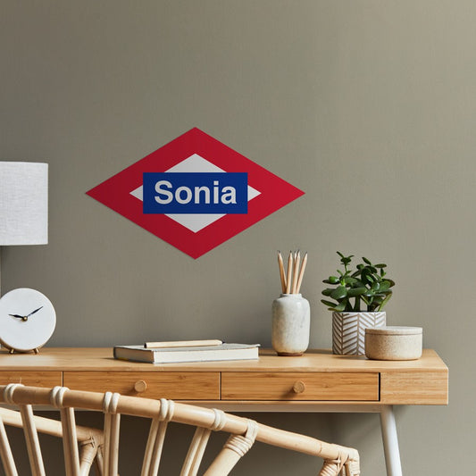 Oficina moderna con letrero de pared rojo y azul que dice Sonia, escritorio de madera y plantas