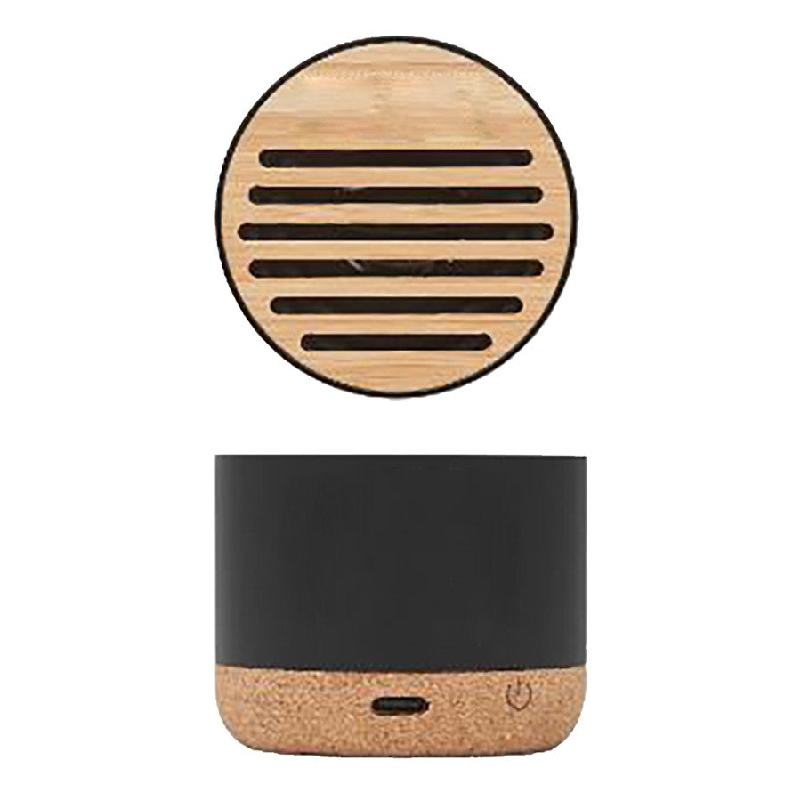 Mini altavoz Bluetooth portátil con base de corcho y rejilla de bambú en fondo blanco