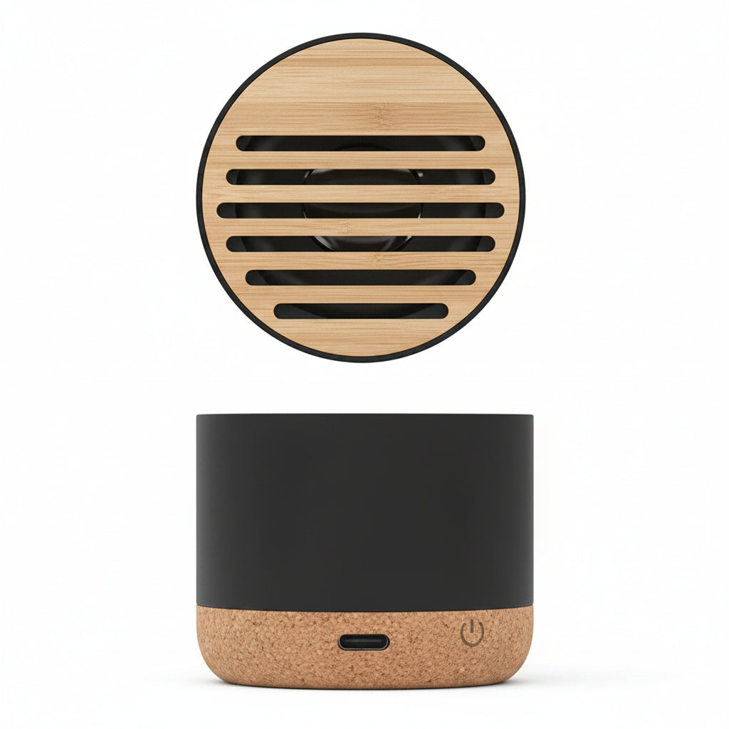 Mini altavoz Bluetooth portátil con base de corcho y rejilla de bambú en fondo blanco