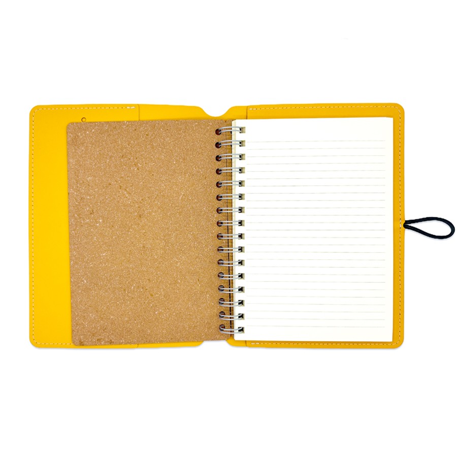 Cuaderno de anillas abierto con portada amarilla y páginas rayadas