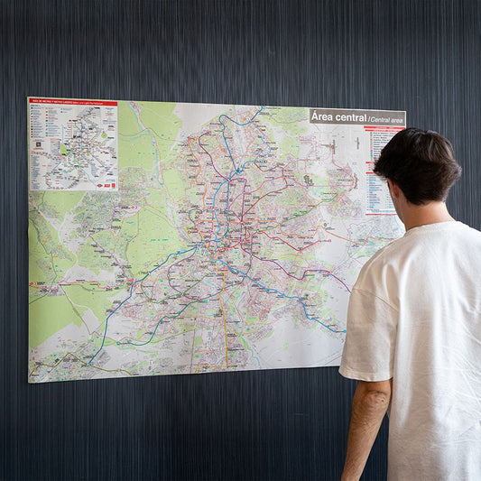 Hombre viendo mapa de metro de Madrid en pared, plano de transporte urbano
