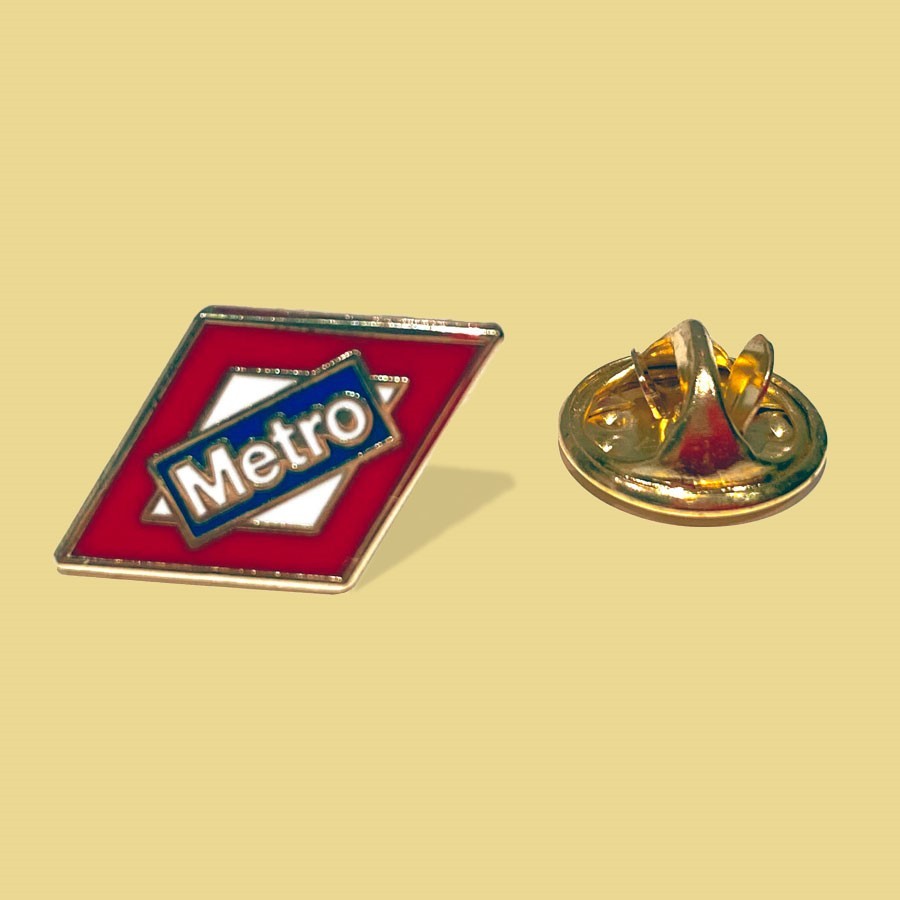 Pin de solapa Metro de Madrid esmaltado rojo y blanco sobre fondo beige
