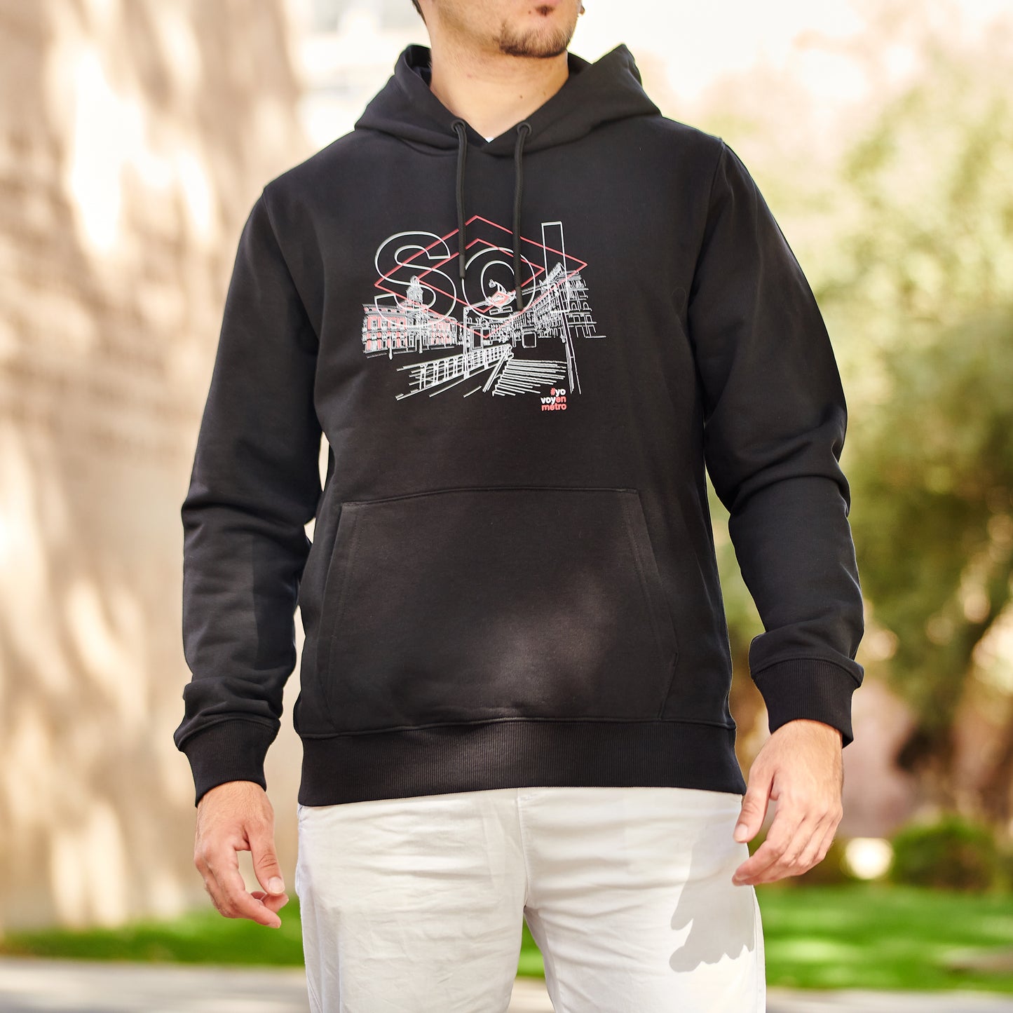 Hombre con sudadera negra Sol Metro Madrid, diseño urbano, fondo al aire libre