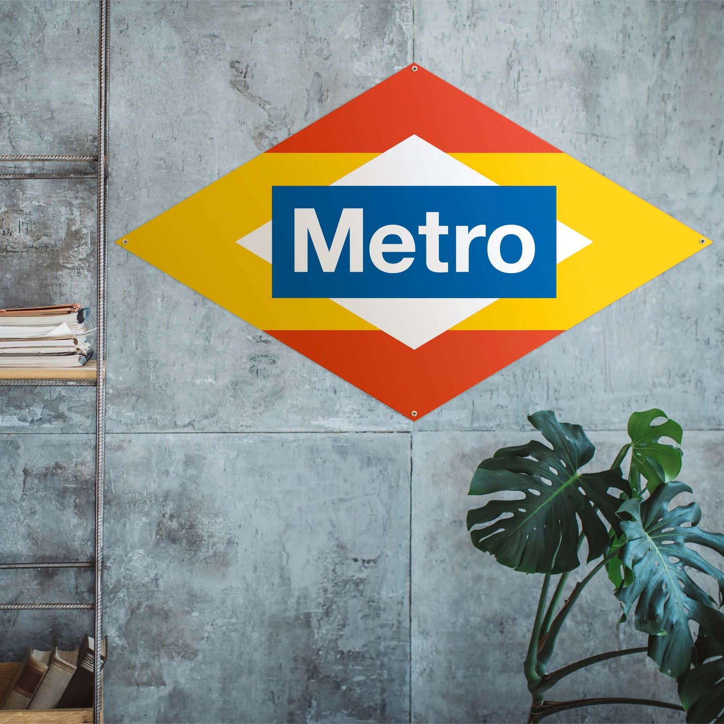 Letrero decorativo Metro en pared de concreto, planta y estante de libros a la izquierda