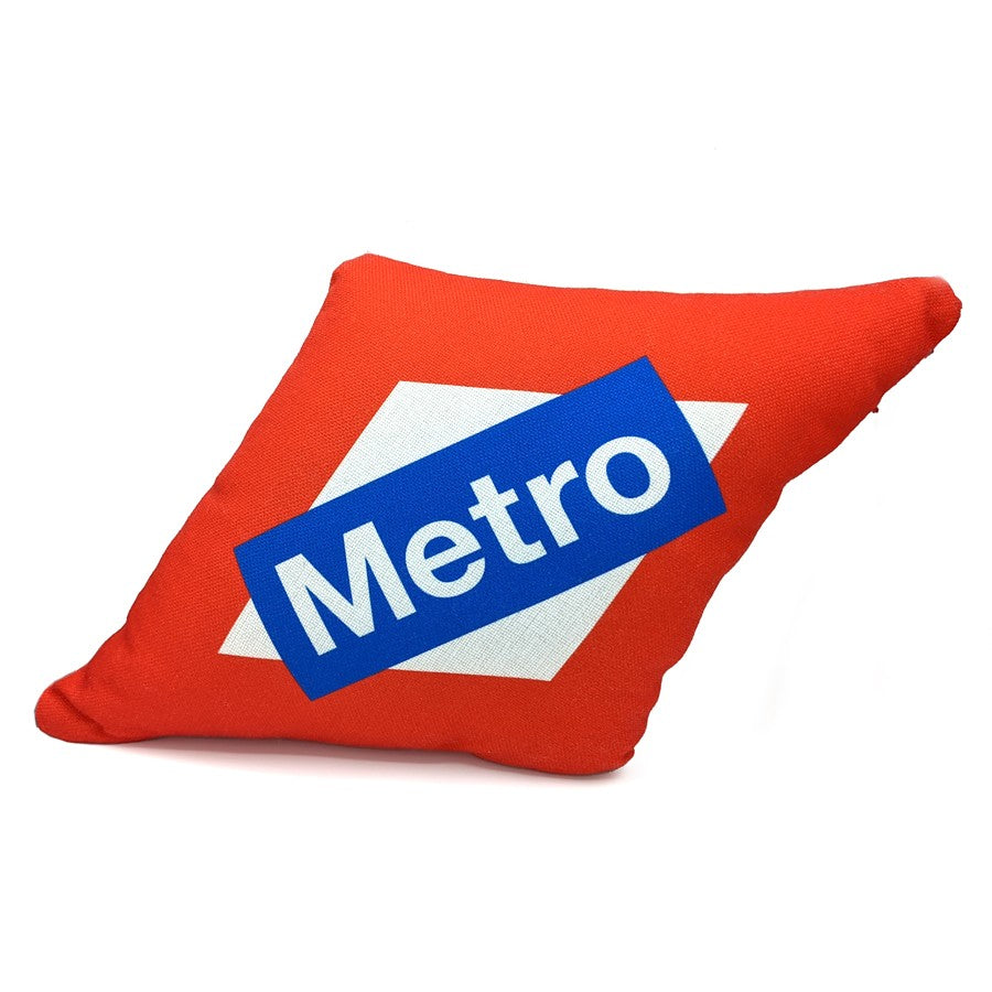Cojín rojo con logo Metro sobre fondo blanco, decoración moderna para hogar u oficina.