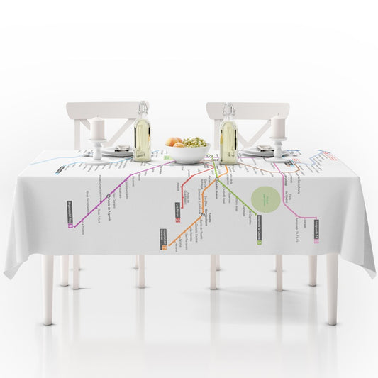 Mesa con mantel estampado de mapa del metro, vajilla blanca y dos botellas sobre la mesa.