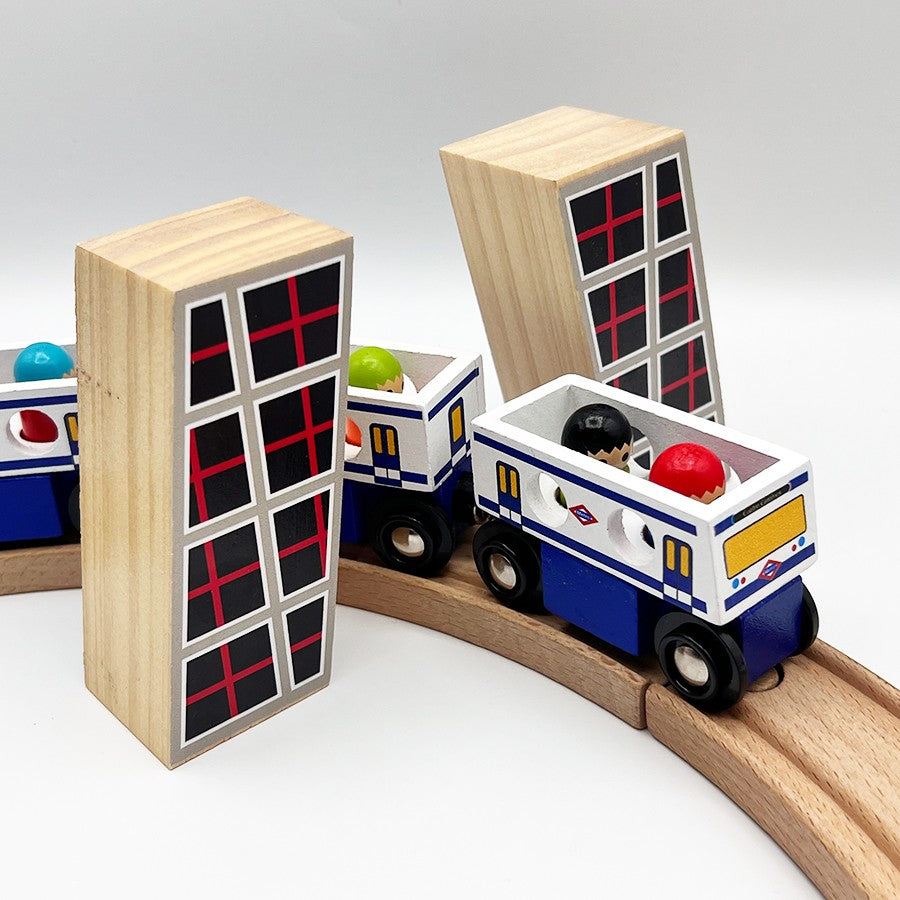 Tren de juguete de madera en vía curva con edificios y pasajeros de colores.