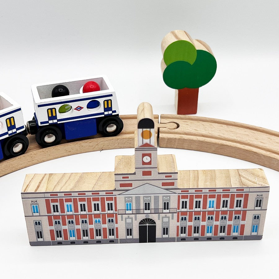 Juguete de tren de madera con edificio de la Puerta del Sol y árbol decorativo