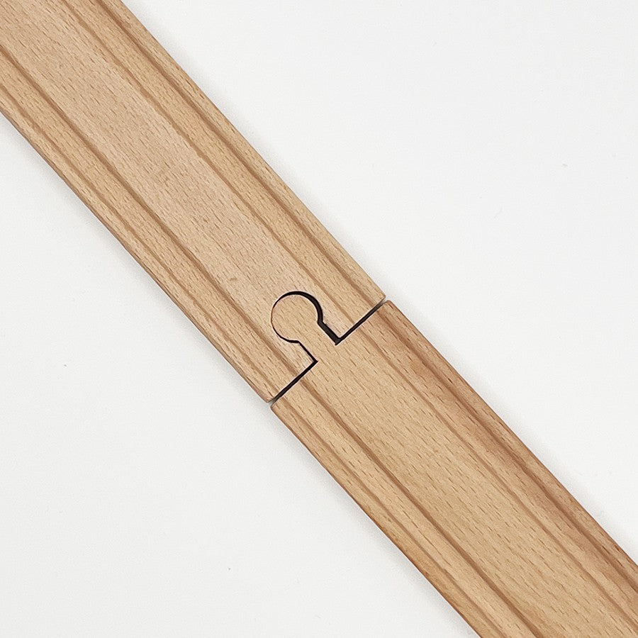 Unión de dos pistas de madera para trenes de juguete sobre fondo blanco