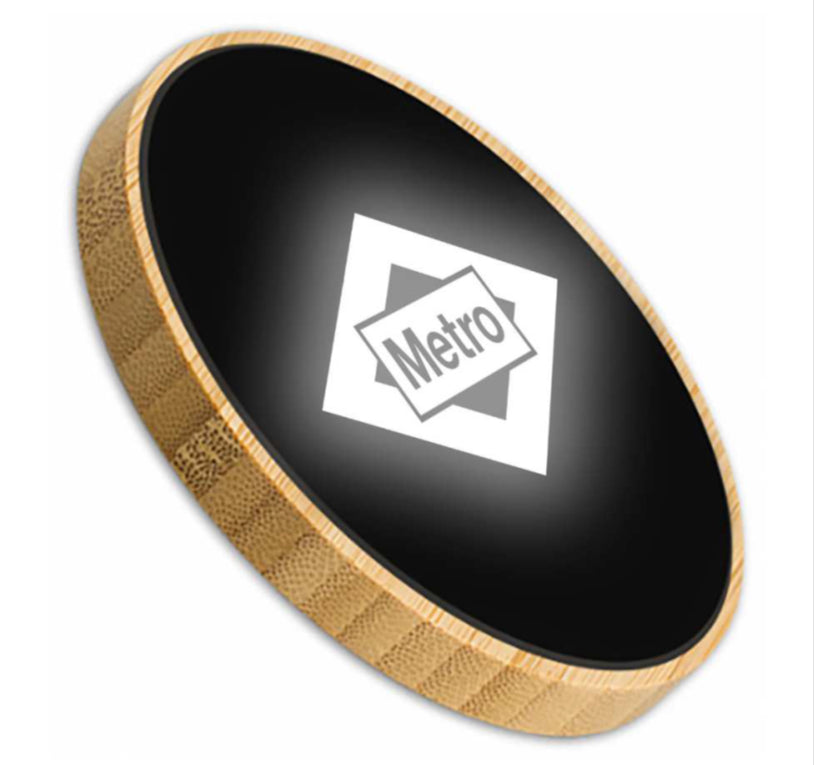 Tapa de madera redonda negra con logo Metro, diseño moderno, fondo blanco