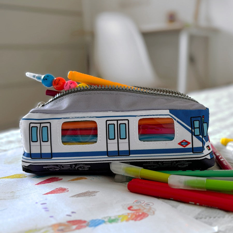 Estuche escolar con forma de metro de Madrid, lleno de bolígrafos sobre dibujo infantil
