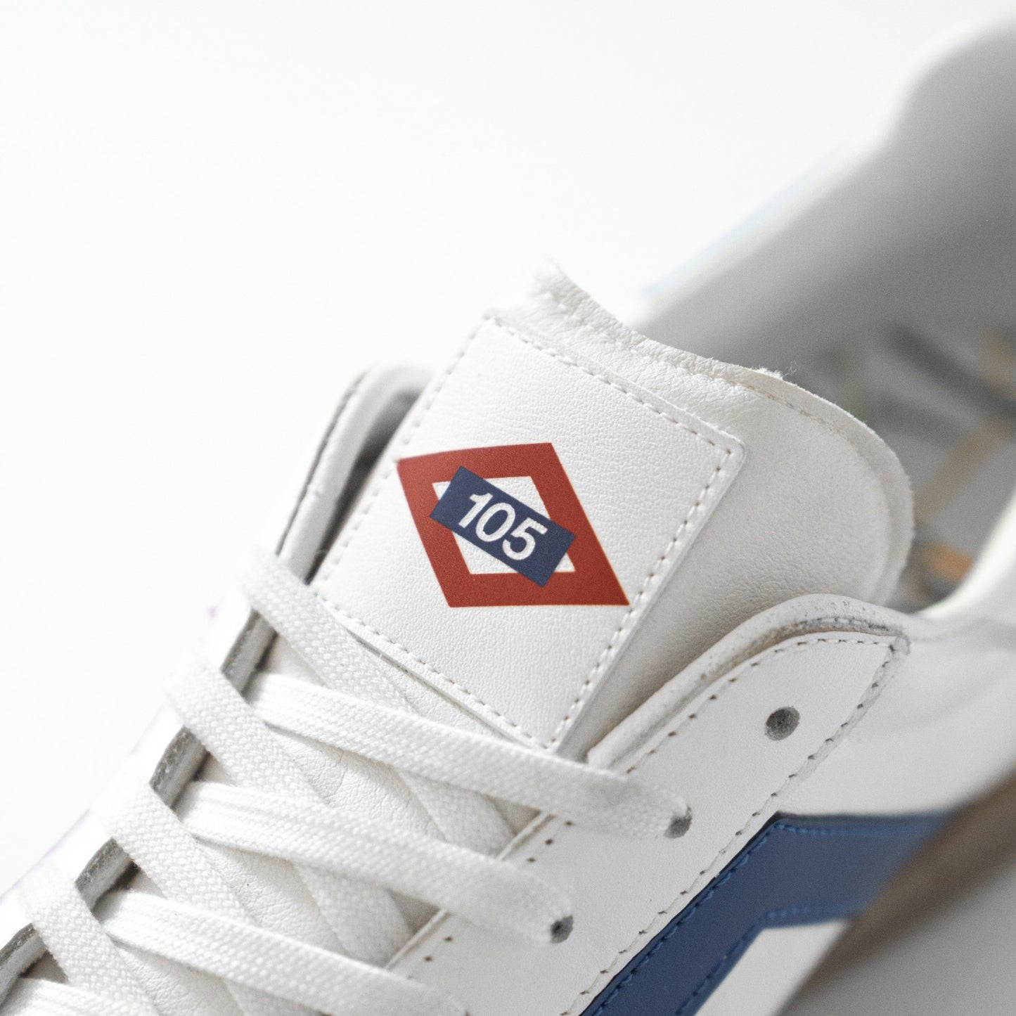 Zapatilla blanca con logo 105 en lengüeta, detalle azul, moda urbana