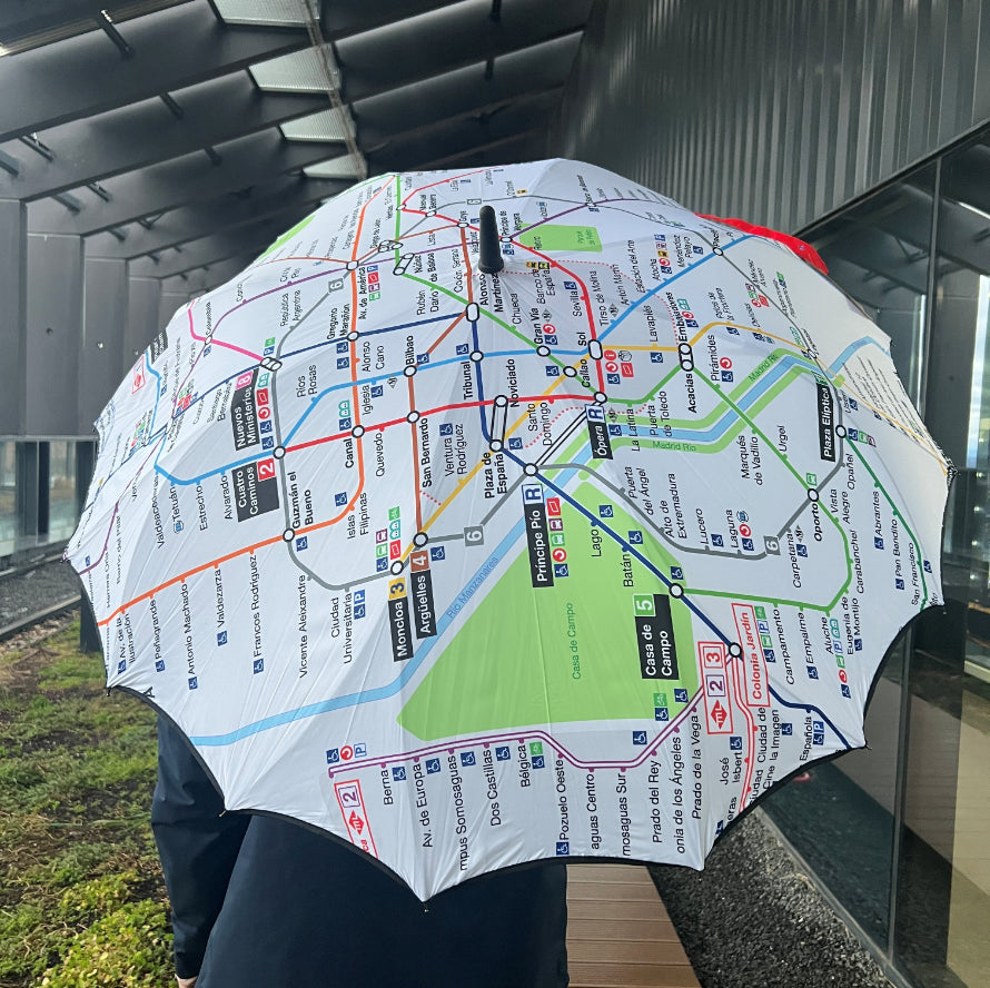 Paraguas con diseño de mapa metro Madrid usado en pasillo moderno, accesorio original urbano