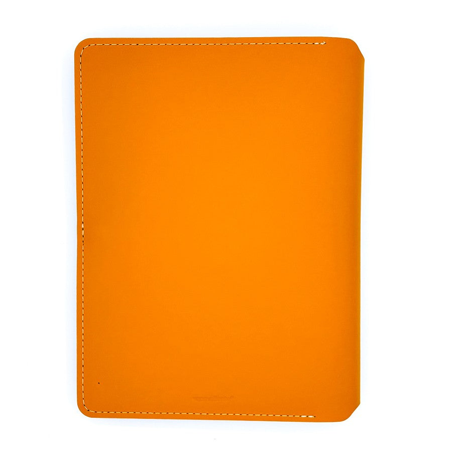 Funda de cuero naranja para cuaderno, vista superior sobre fondo blanco