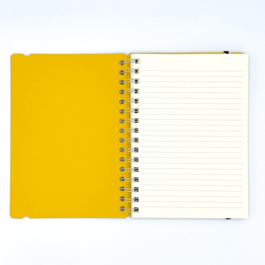 Cuaderno de anillas abierto con tapa amarilla y hojas rayadas sobre fondo blanco