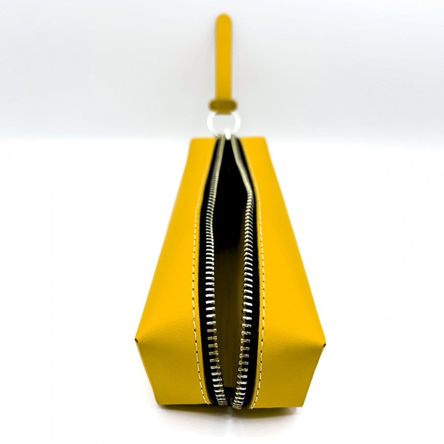 Neceser amarillo rectangular con cremallera y asa, fondo blanco minimalista