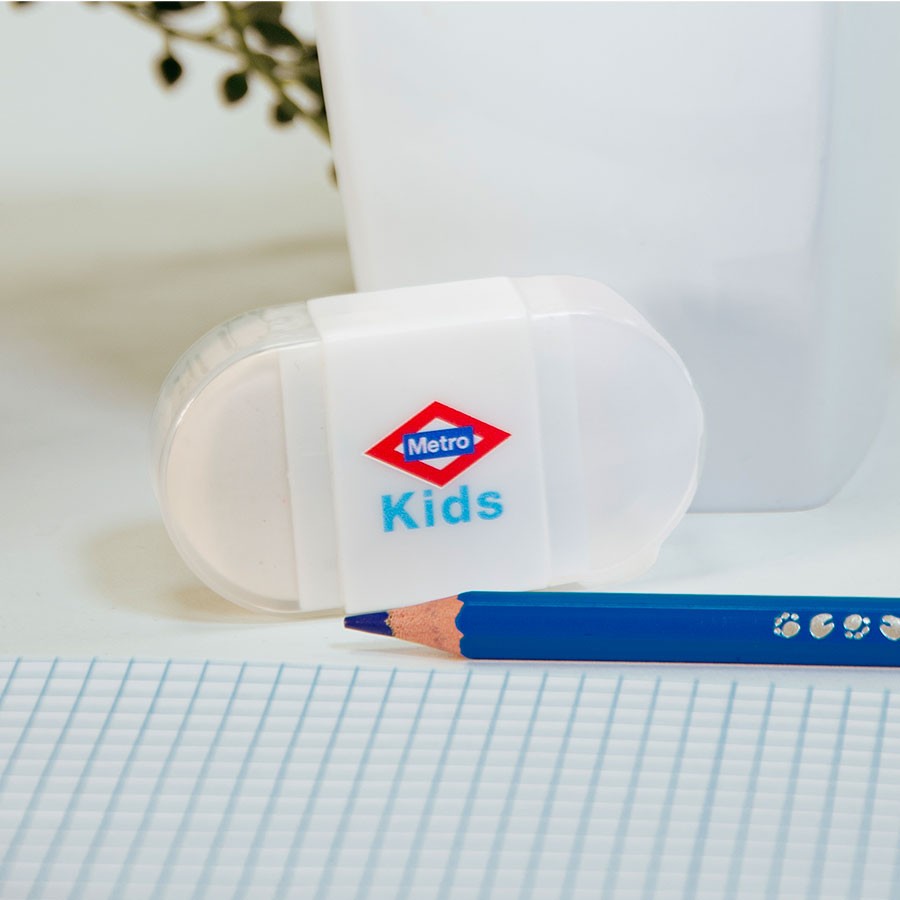 Sacapuntas blanco Metro Kids con lápiz azul y hoja cuadriculada en escritorio escolar