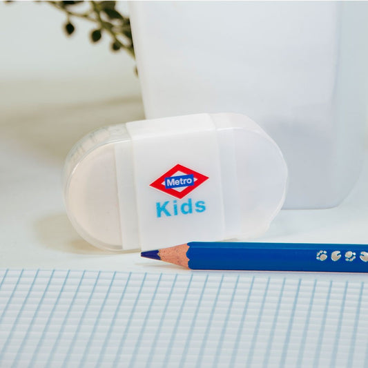 Sacapuntas blanco Metro Kids con lápiz azul y hoja cuadriculada en escritorio escolar