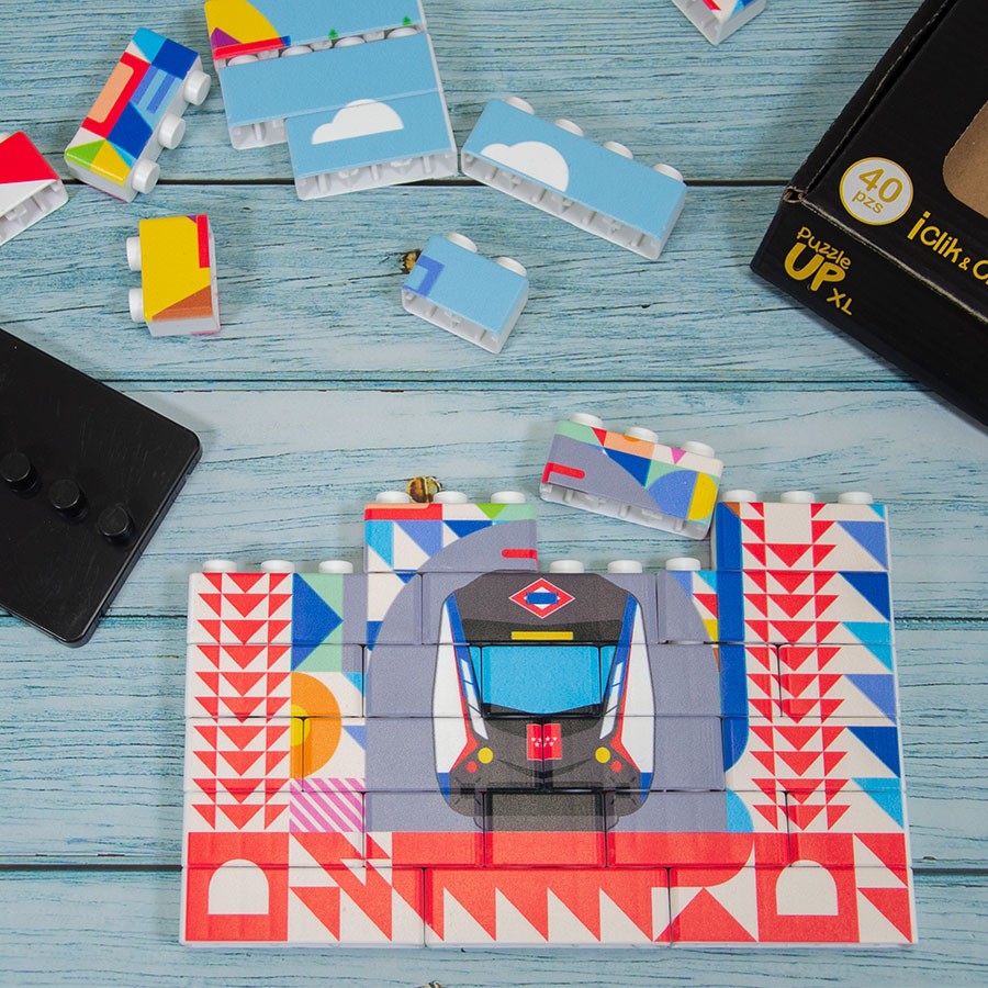 Puzzle de bloques con dibujo de metro de Madrid, piezas coloridas sobre mesa azul