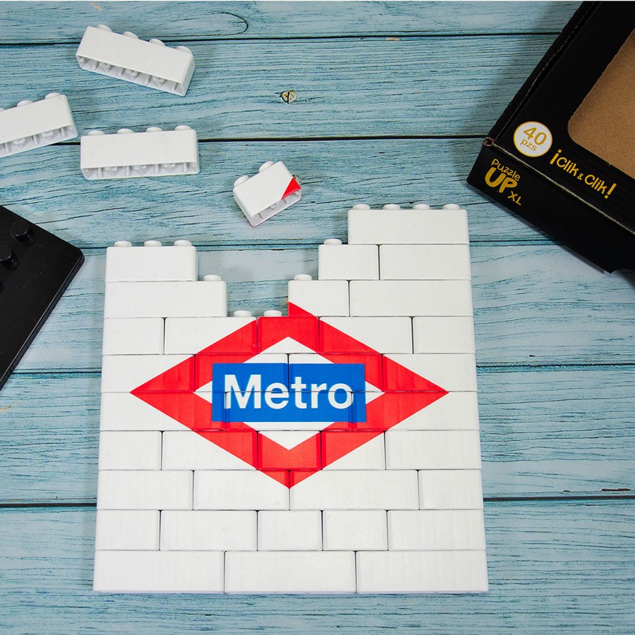 Puzzle de bloques blancos con el logo del Metro de Madrid sobre mesa azul