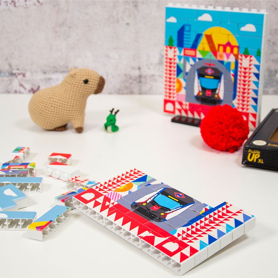 Rompecabezas de bloques con diseño de metro, peluche de capibara y decoración en mesa blanca