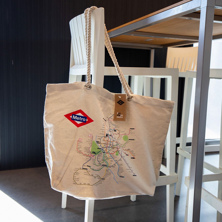 Bolsa de tela beige con mapa del metro de Madrid y asa de cuerda, sobre silla blanca
