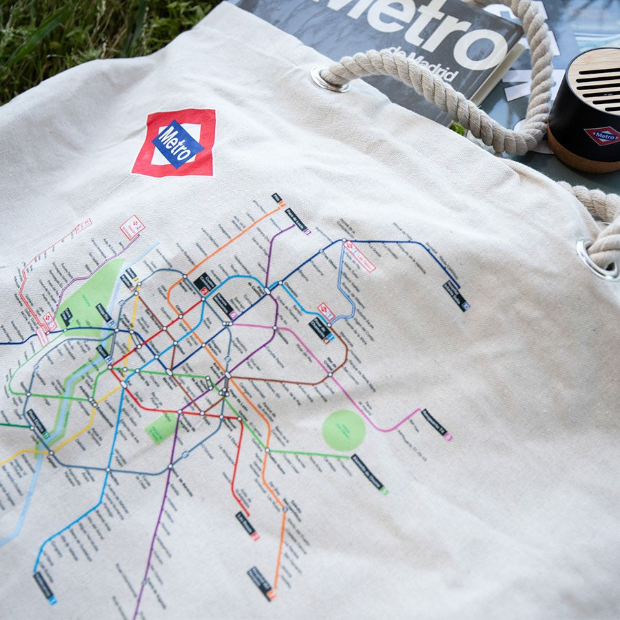 Bolsa de tela beige con mapa del Metro de Madrid impreso y logotipo, sobre césped