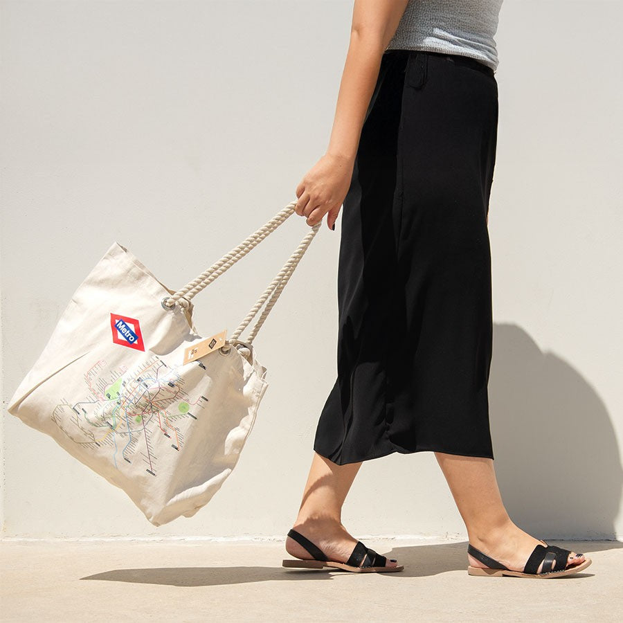 Bolso de lona beige con estampado de mapa del metro y asas de cuerda, mujer caminando
