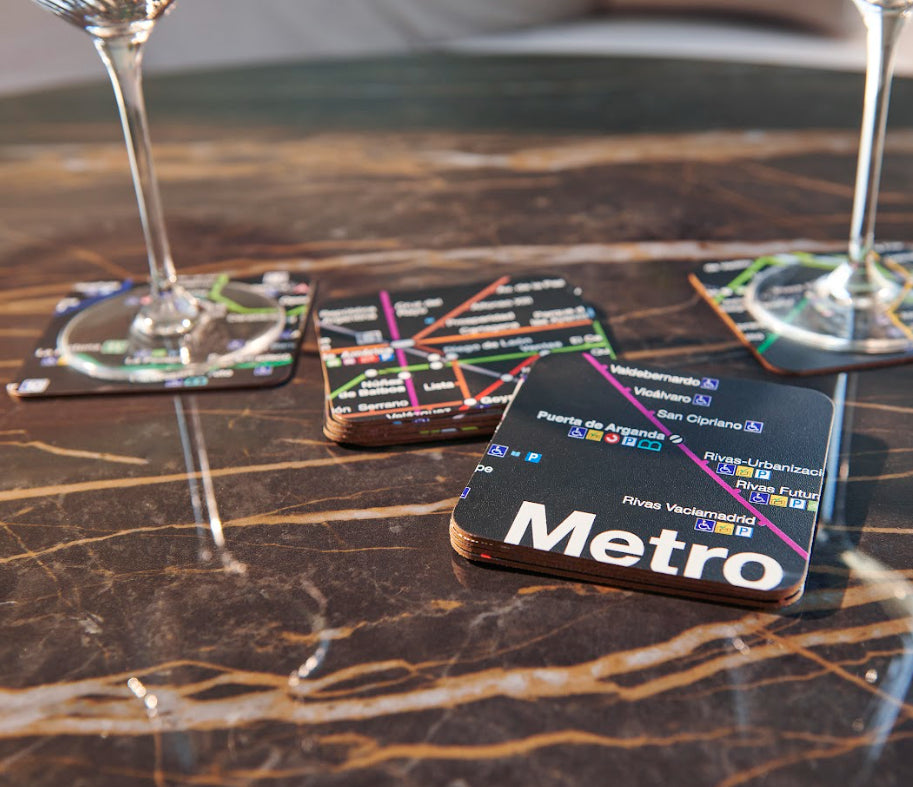 Posavasos diseño mapa metro sobre mesa de mármol con copas de vino