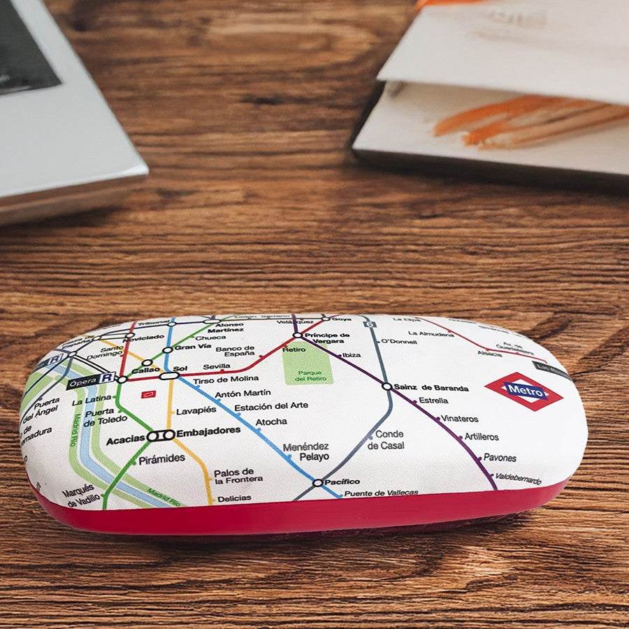 Estuche de gafas con diseño de mapa del metro de Madrid sobre mesa de madera