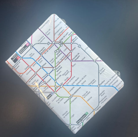 Cuaderno con portada de mapa del metro de la Ciudad de México sobre fondo gris.