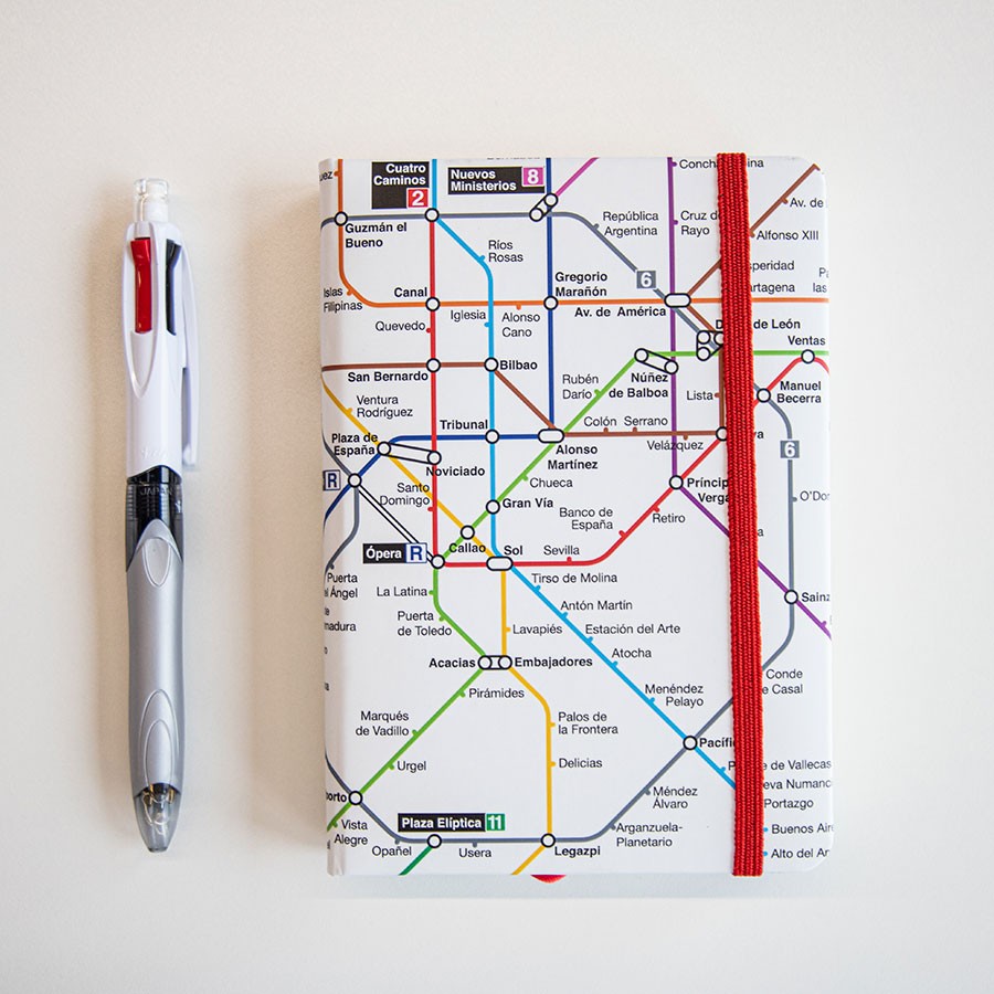 Libreta con diseño de mapa del metro de Madrid y bolígrafo sobre fondo blanco
