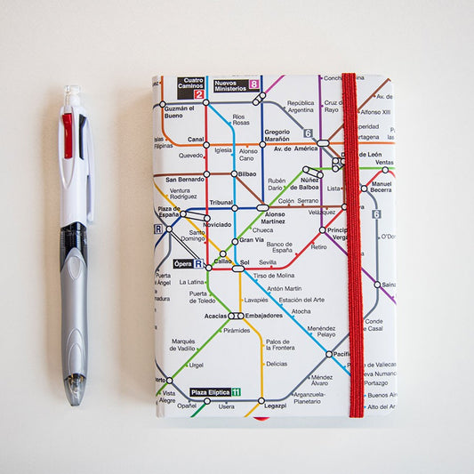 Libreta con diseño de mapa del metro de Madrid y bolígrafo sobre fondo blanco