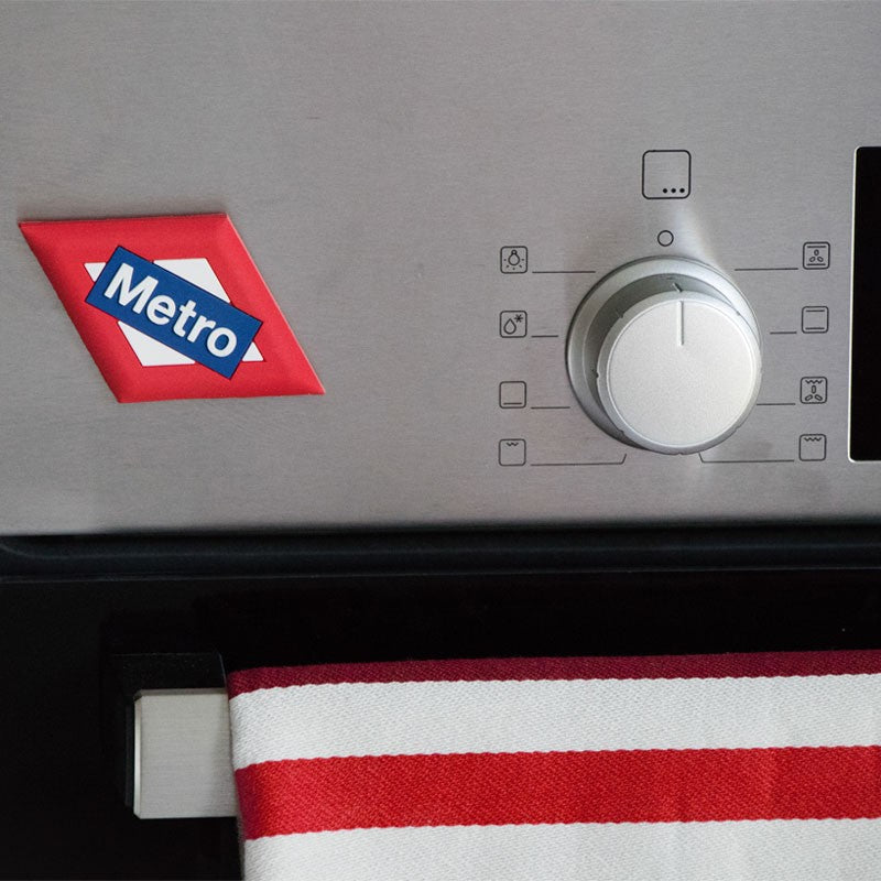 Panel de acero inoxidable con imán Metro y paño rayado rojo en horno moderno