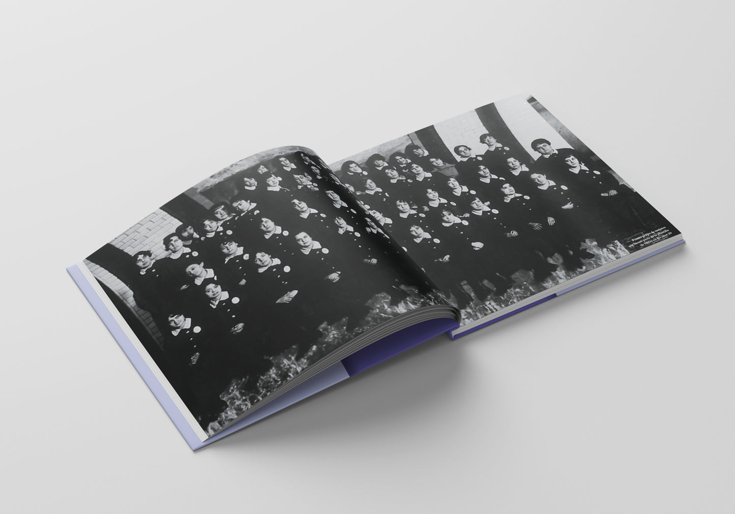 Libro abierto con fotografía antigua en blanco y negro de grupo de mujeres, fondo blanco