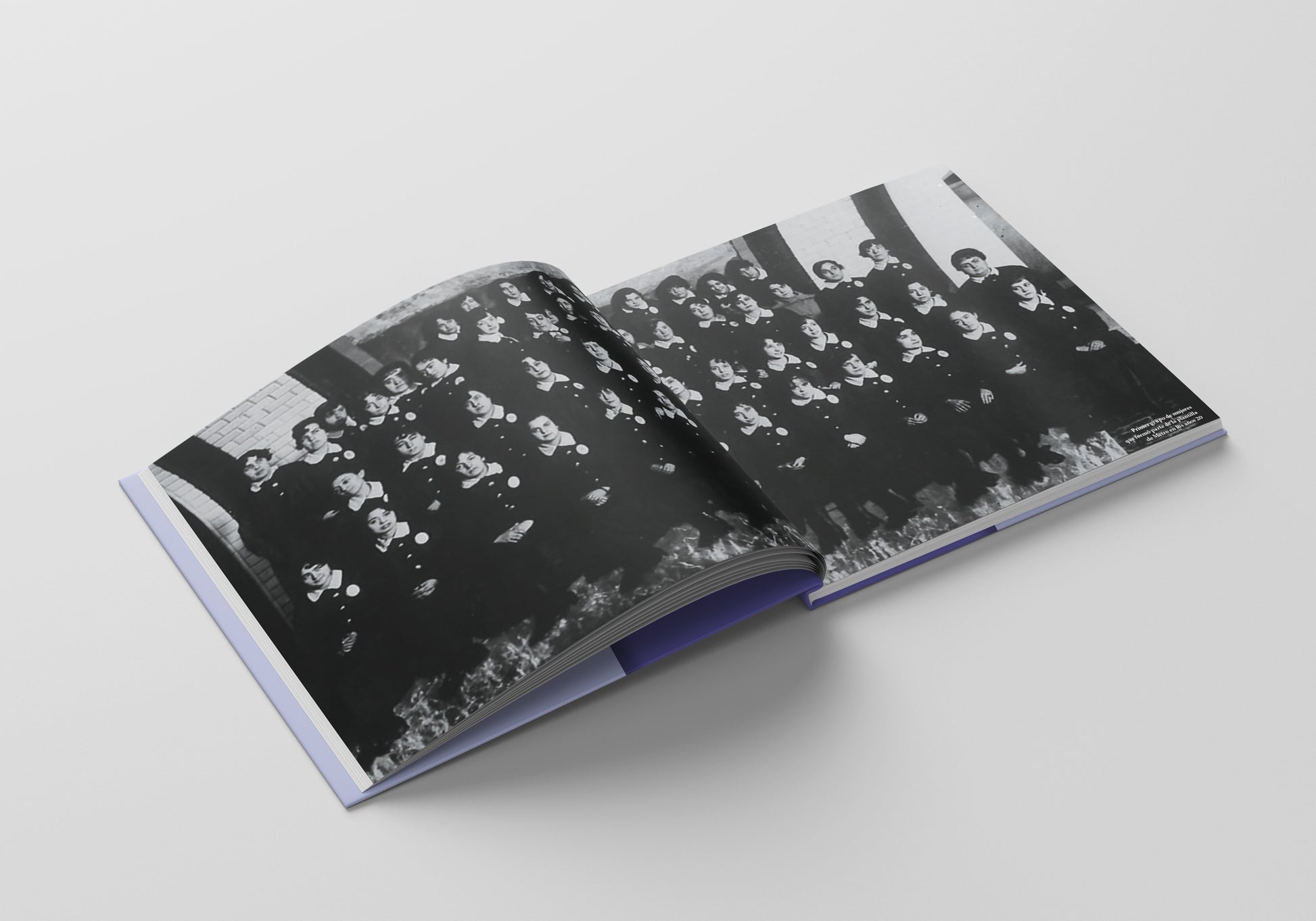 Libro abierto con fotografía antigua en blanco y negro de grupo de mujeres, fondo blanco