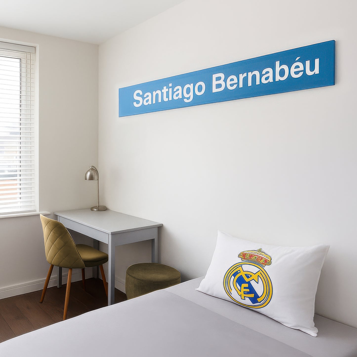 Dormitorio moderno con temática de Real Madrid, cartel Santiago Bernabéu y almohada del club
