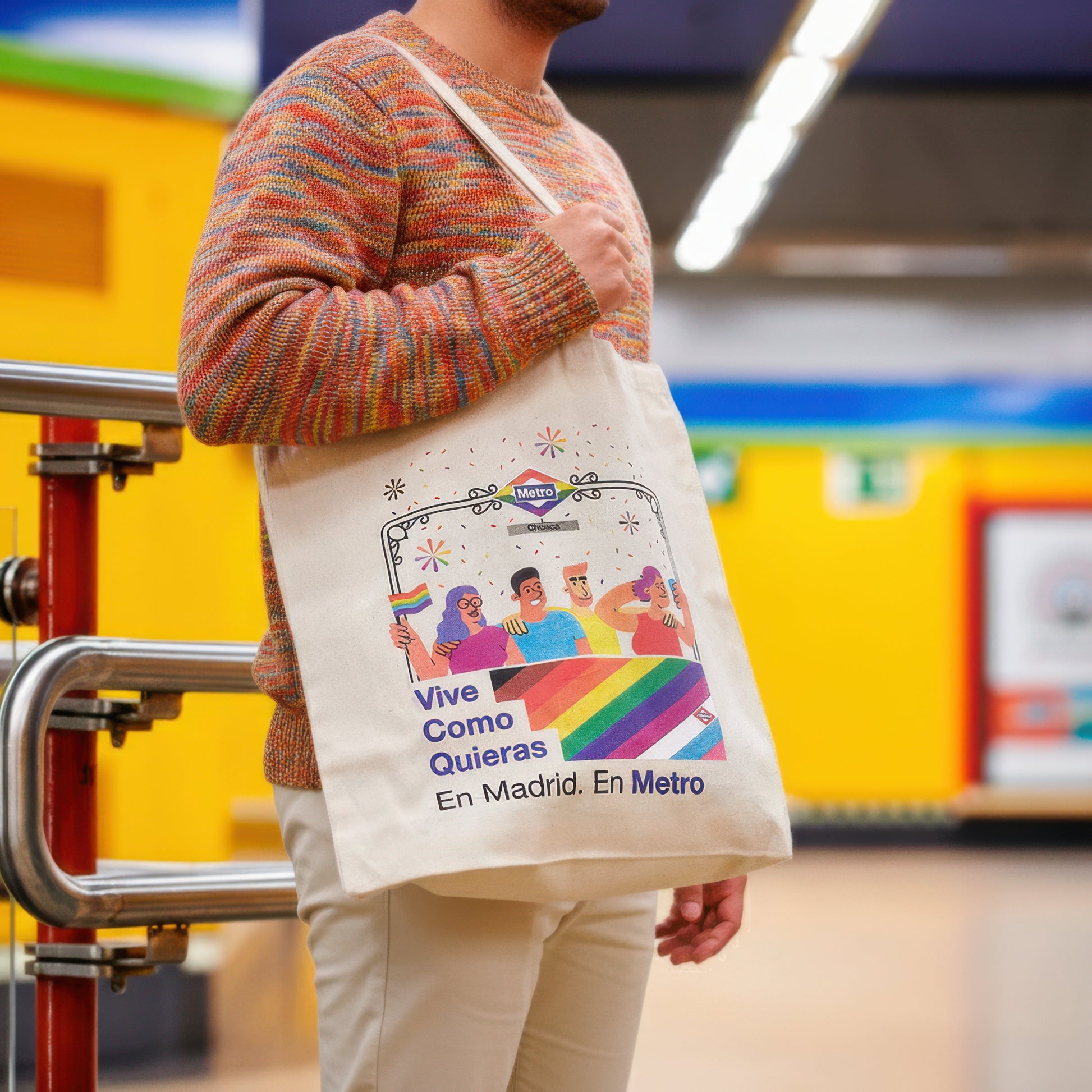 Persona con bolso LGTBI con arcoíris y mensaje inclusivo en estación de metro de Madrid