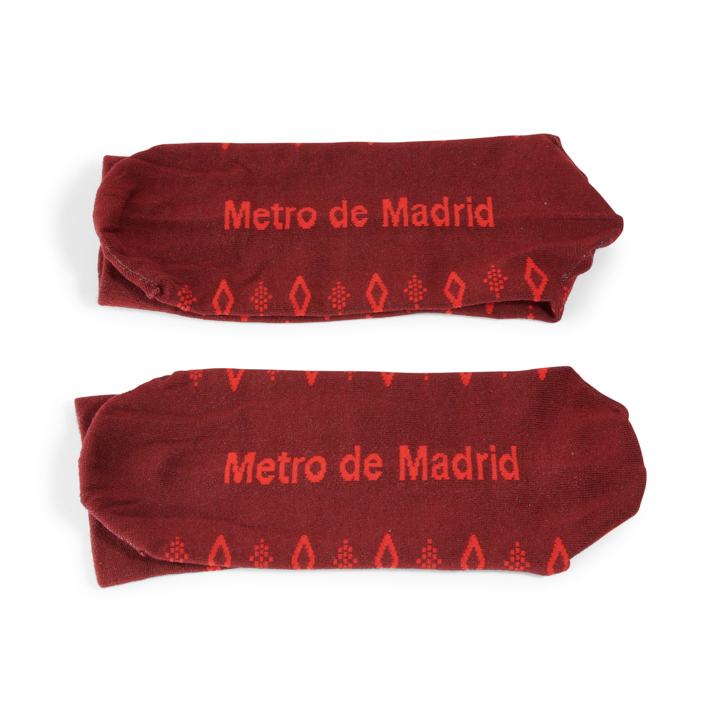 Calcetines rojos con texto Metro de Madrid y patrón geométrico, fondo blanco.