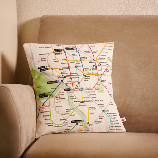 Cojín con diseño de mapa del metro de Madrid sobre un sofá beige en sala de estar
