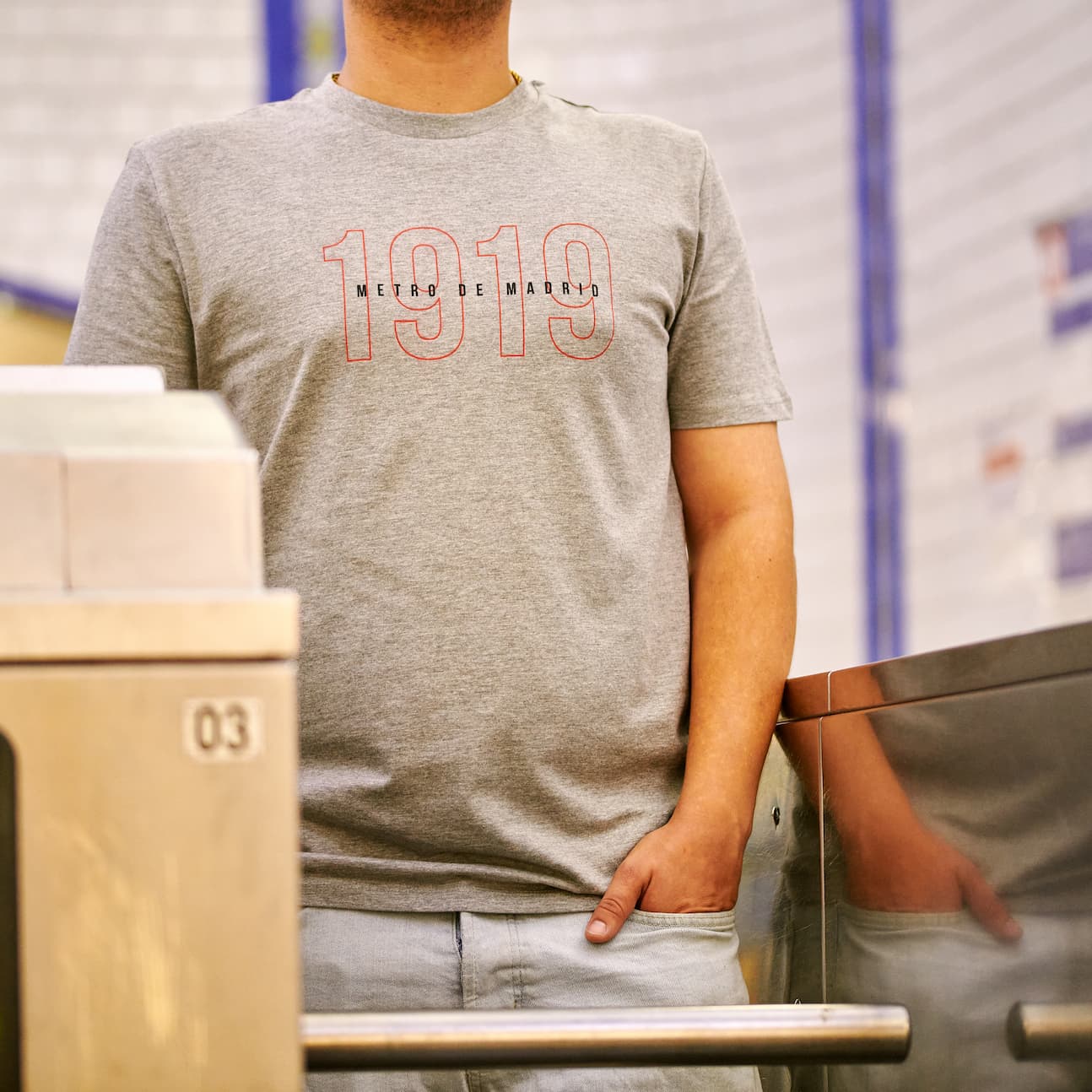 Hombre con camiseta gris Metro de Madrid 1919 junto a torniquete en estación de metro