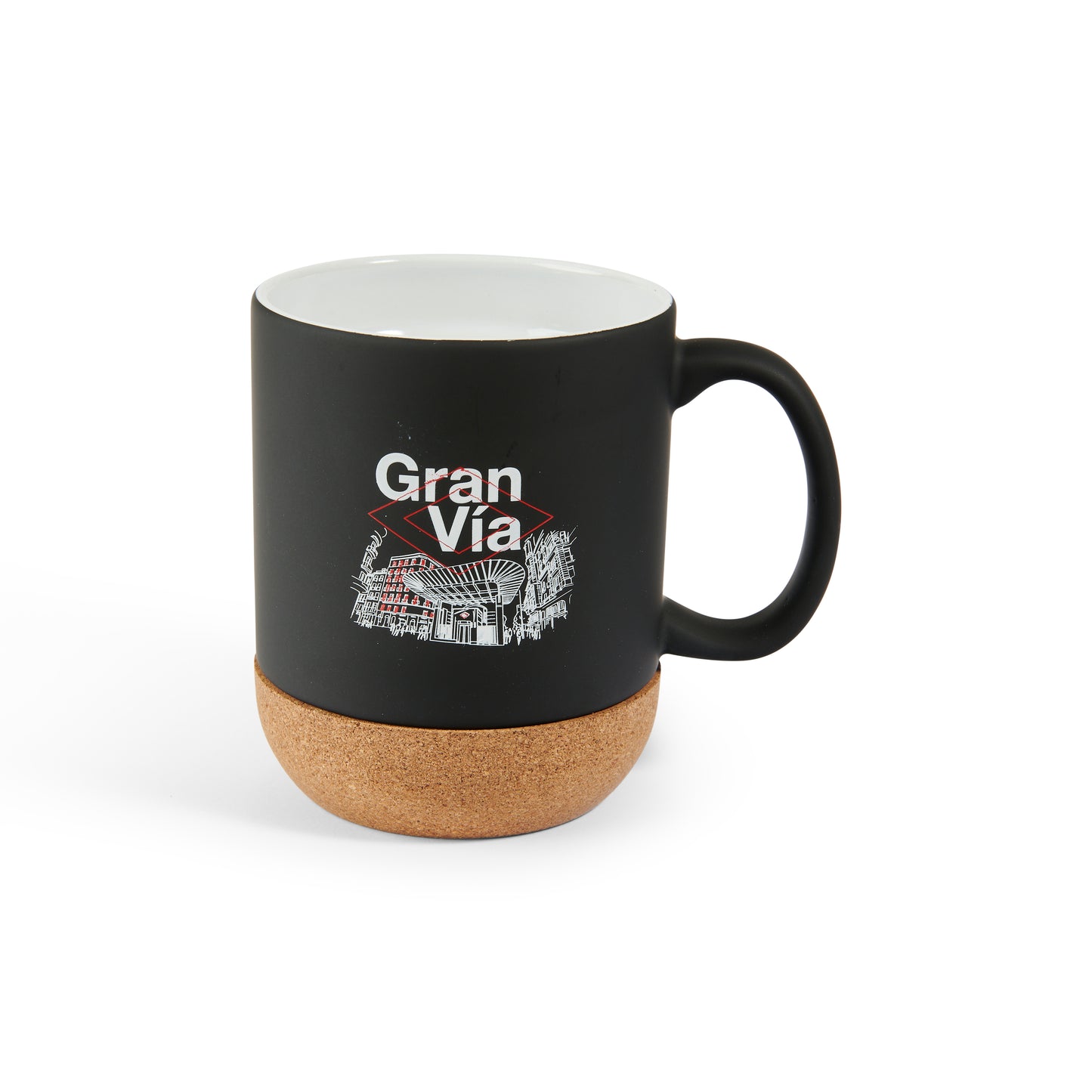 Taza negra con base de corcho y diseño de Gran Vía, ideal para café y souvenirs de Madrid.