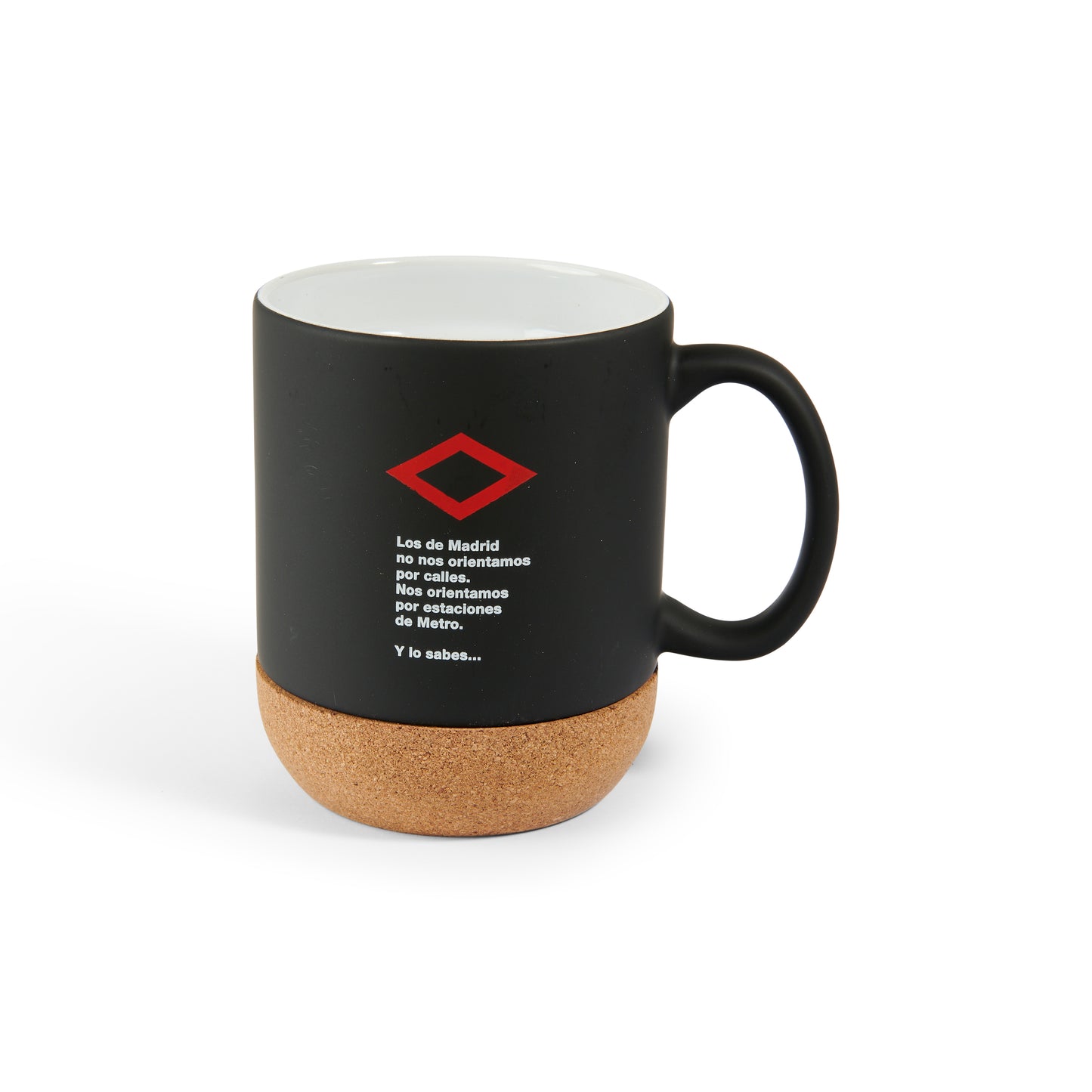 Taza negra con base de corcho y texto sobre el Metro de Madrid con logotipo rojo.