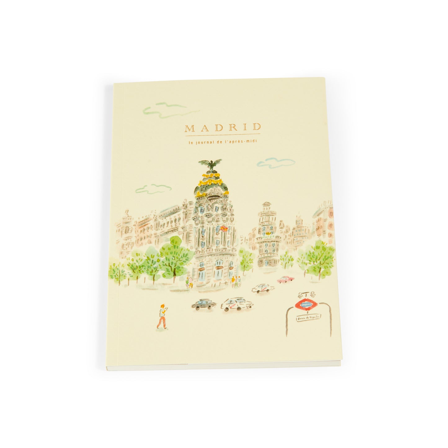 Cuaderno con portada ilustrada de edificio Metropolis Madrid y entrada de metro, fondo claro