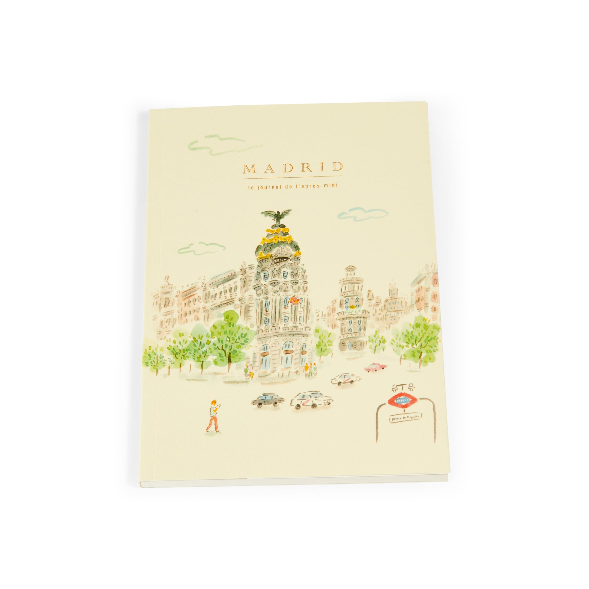 Cuaderno con portada ilustrada de edificio Metropolis Madrid y entrada de metro, fondo claro