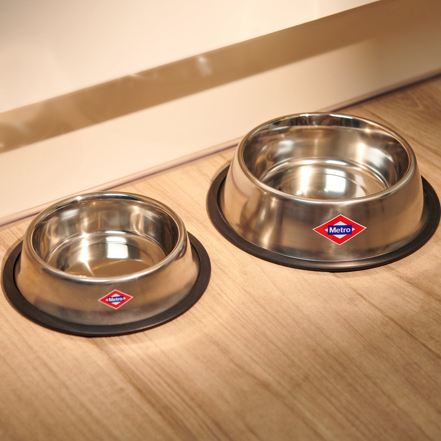 Dos comederos de acero inoxidable para mascotas Metro sobre suelo de madera