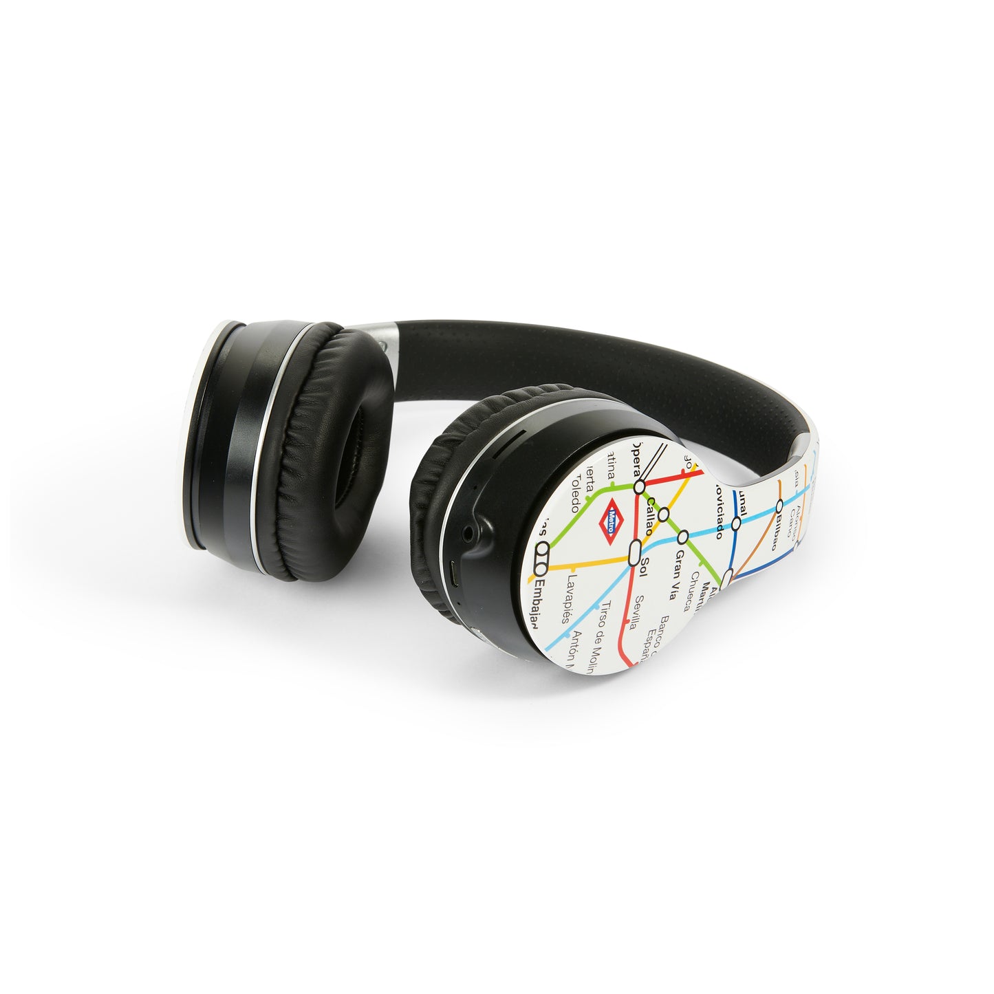 Auriculares inalámbricos negros con diseño de plano del metro de Madrid sobre fondo blanco