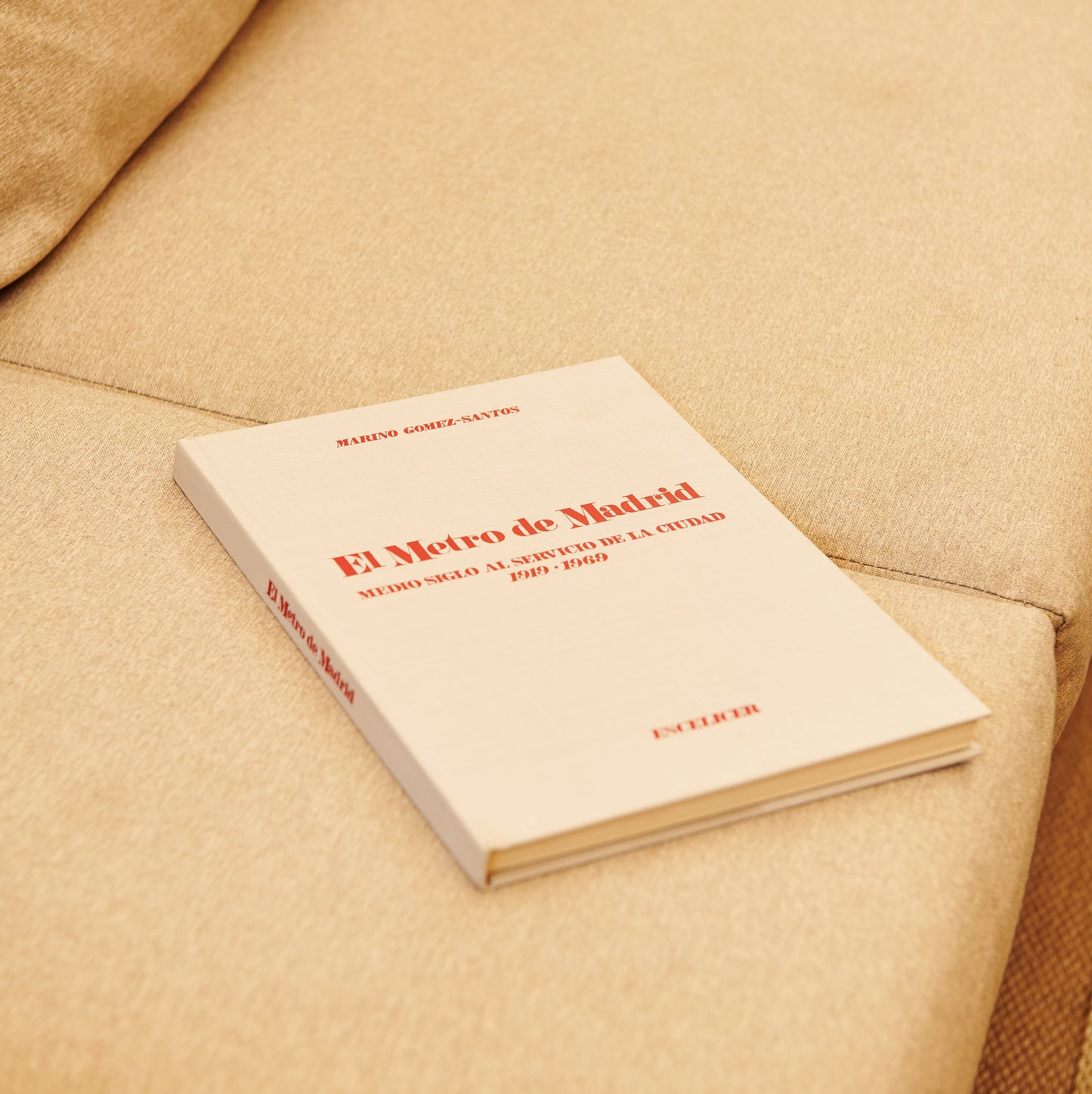 Libro El Metro de Madrid sobre sofá beige, portada visible, historia transporte Madrid