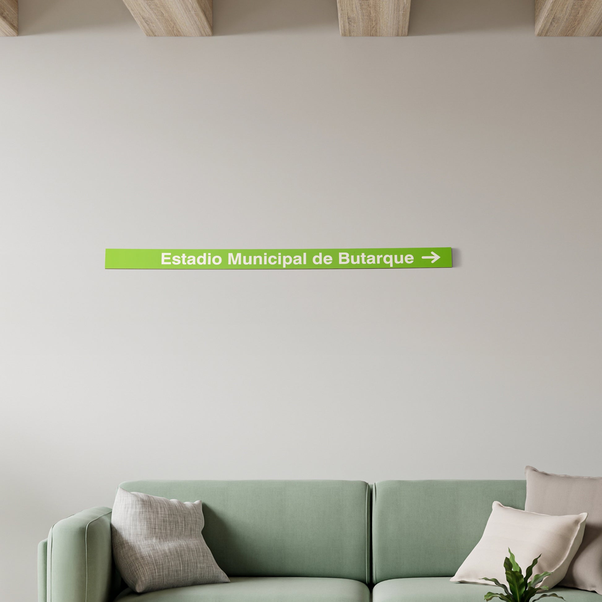 Sala moderna con sofá verde y letrero verde 'Estadio Municipal de Butarque' en la pared